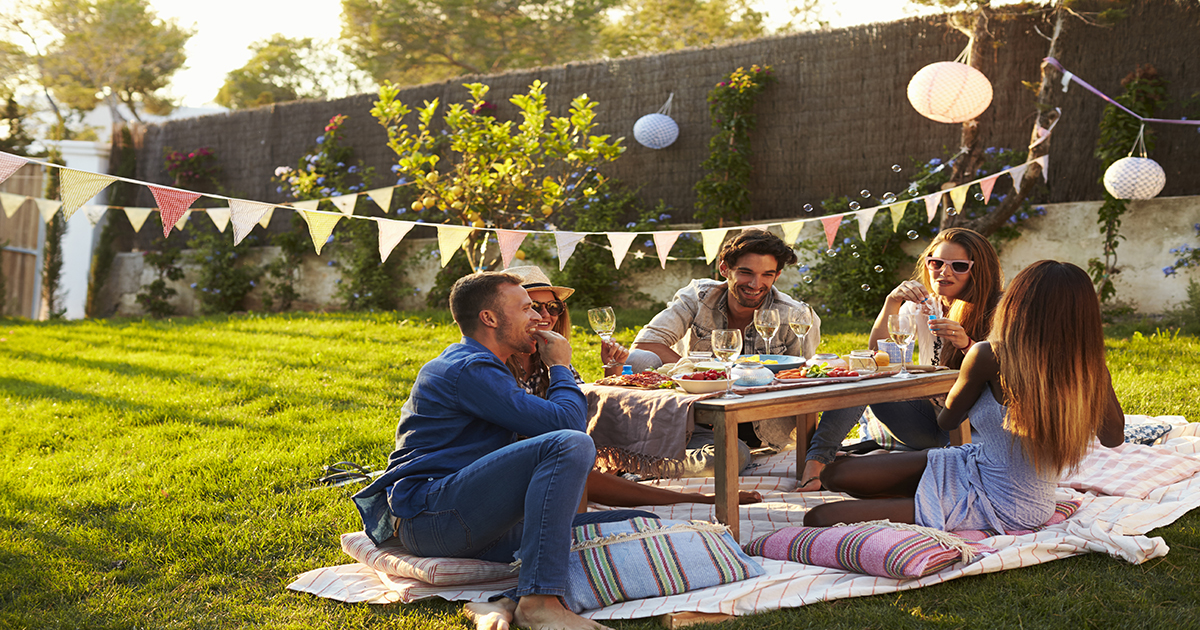 Group of friends enjoying a picnic in the back yard.